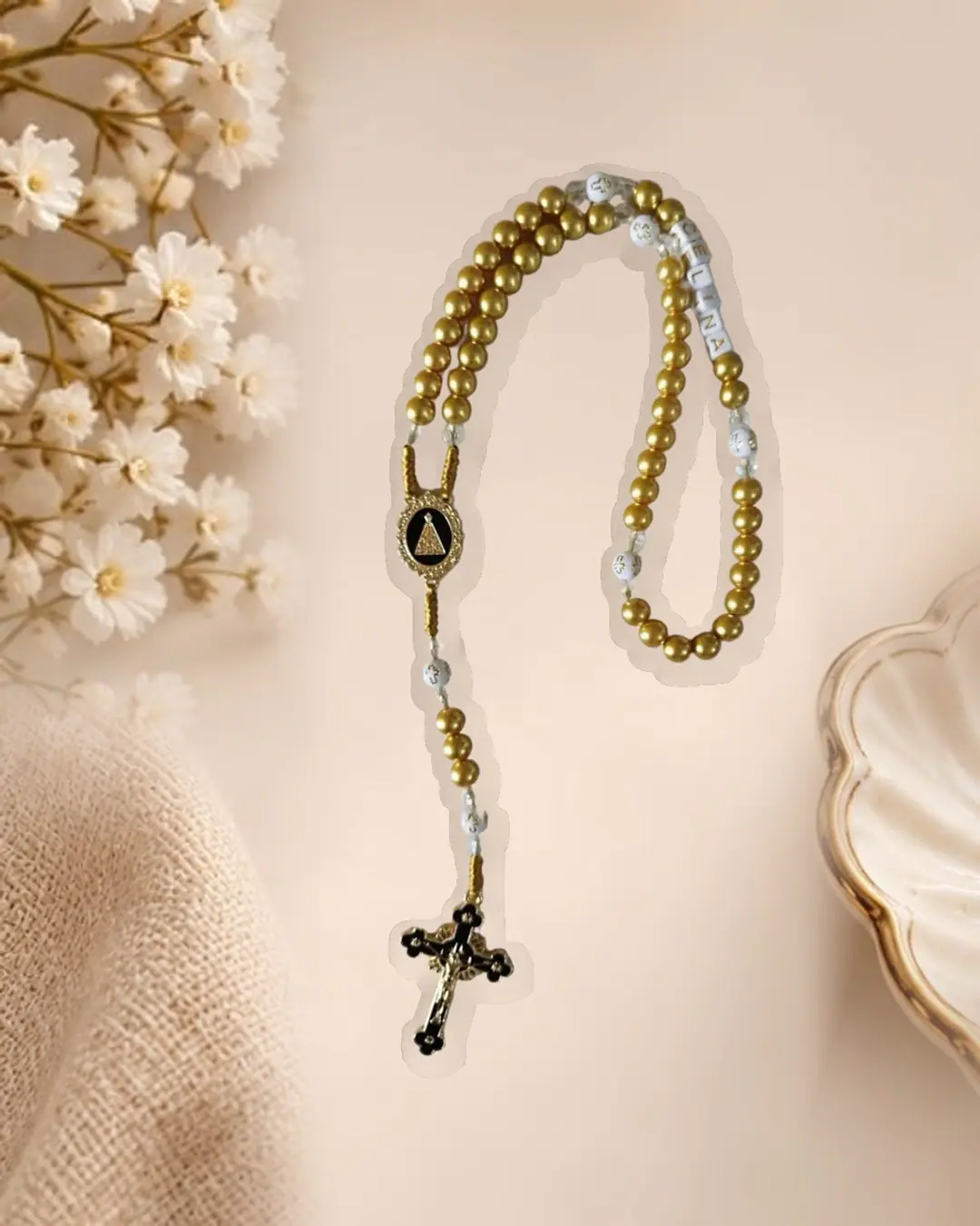 Terço com contas douradas e brancas e crucifixo escuro